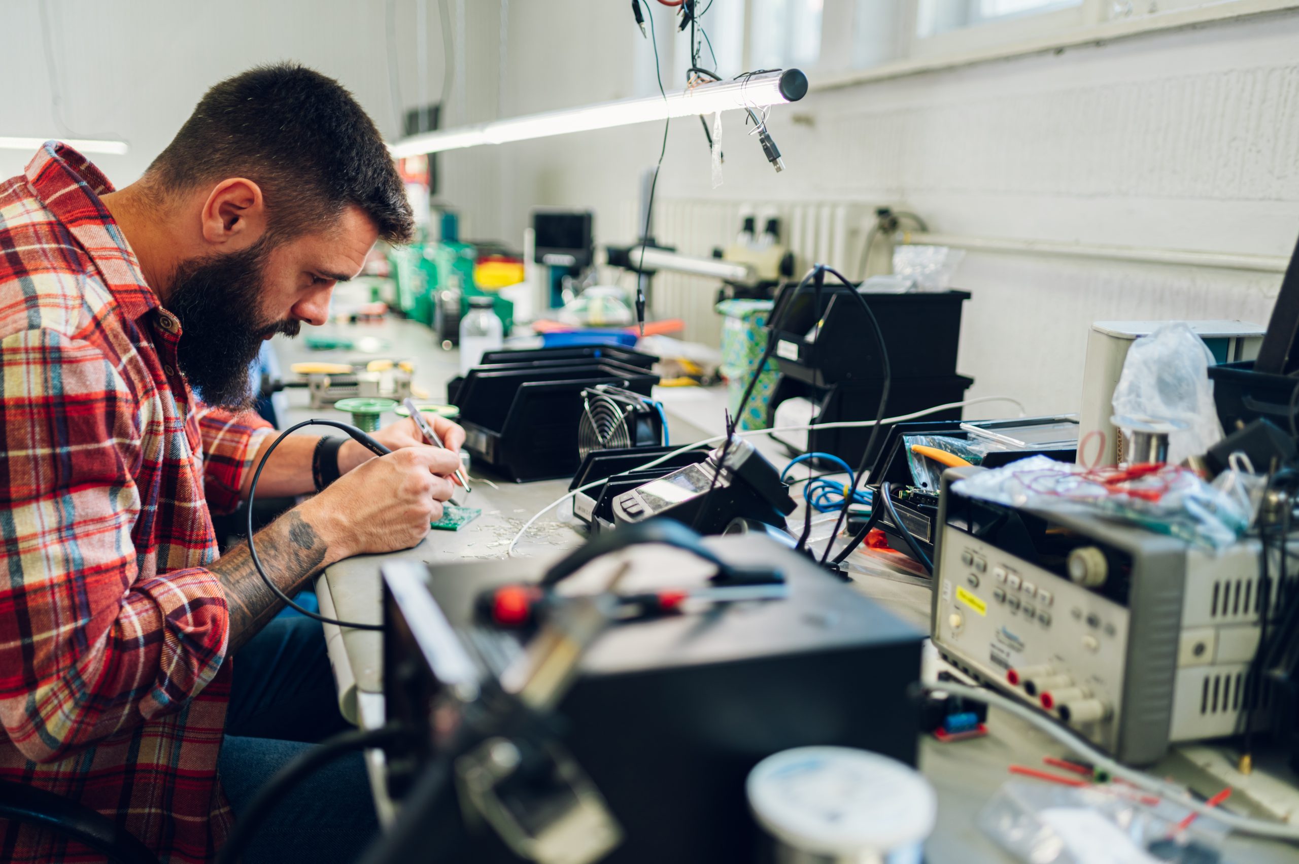 Electronics engineer working in a workshop with tin soldering pa