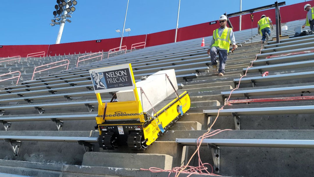 Stair climbing robot transporting precast concrete in a stadium